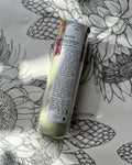 A Geisha Magnesium Bath Soak tube sits against a floral background