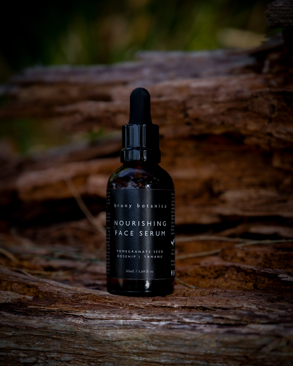 Bottle of Nourishing Face Serum on a hollowed log